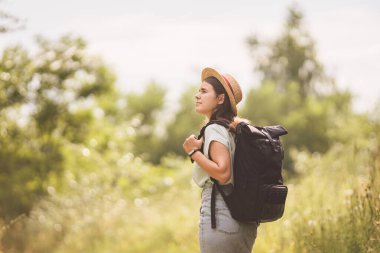 Genç gezgin kız bakış açısıyla. Sırt çantalı hippi kız. Seyahat konsepti. Güzel kadın yürüyüşçü muhteşem manzaraların tadını çıkarıyor. Tatil ve özgürlük. Arkadan bak. Doğada Yürüyen Gezgin.