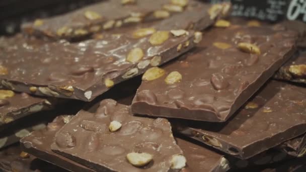 Close Grandes Pedaços Chocolate Com Nozes Uma Vitrine Através Vidro — Vídeo de Stock