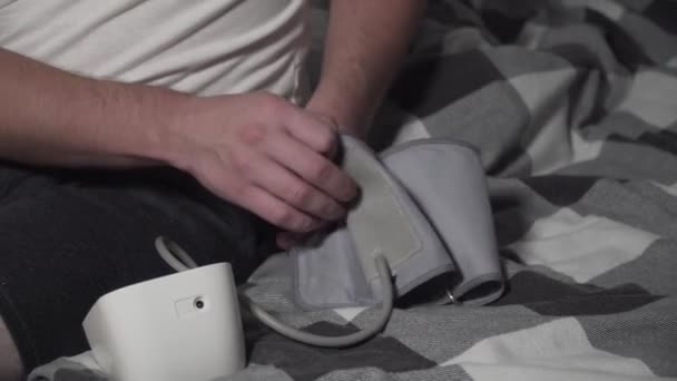 Beyaz Bir Genç Yatak Odasındaki Kan Basıncını Ölçüyor Kıyafetleri Içinde — Stok video