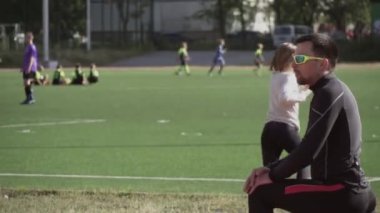 2 Mart 2019. Ukrayna, Kiev. Tema spor ve sağlık. Genç beyaz adam ısınmak için egzersiz yapıyor. Stadyum koşu bandında koşmadan önce ısınma kaslarını çalıştırıyor.