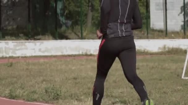 2. března2019. Ukrajina, Kyjev. Téma sport a zdraví. Mladý kavkazský muž dělá cvičení zahřát běží běhání na městském stadionu běžecký pás — Stock video