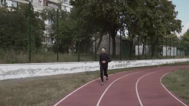 2. března2019. Ukrajina, Kyjev. Téma sport a zdraví. Mladý kavkazský muž dělá cvičení zahřát běží běhání na městském stadionu běžecký pás — Stock video