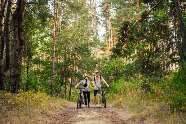 Cycling People. Couple cycle MTB trail track. Outdoor sport activity. Couple With Bikes In Forest. Together on cycle ride in countryside. romantic trip by bicycles. active weekend. sport couple.