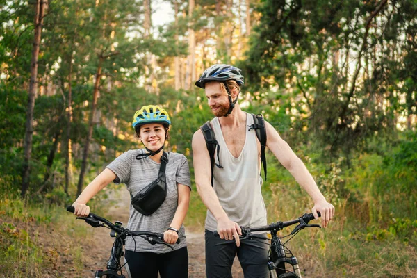 Cycling People. Couple cycle MTB trail track. Outdoor sport activity. Couple With Bikes In Forest. Together on cycle ride in countryside. romantic trip by bicycles. active weekend. sport couple.
