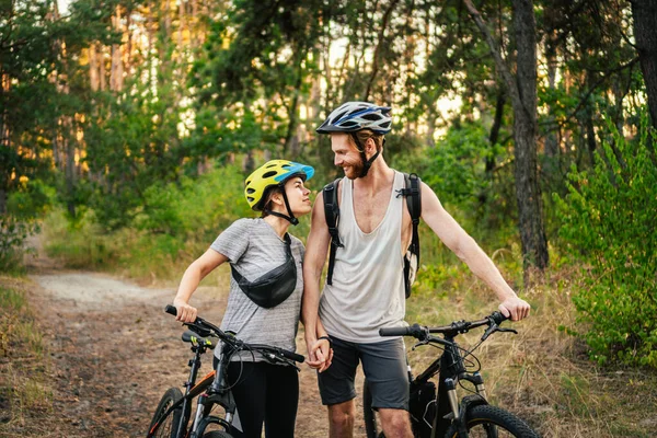 Bisikletli İnsanlar. Birkaç döngü MTB patika yolu. Açık hava spor aktivitesi. Ormanda Bisikletli Çift. Kırsalda bisiklet sürerken. Bisikletle romantik bir gezi. Aktif hafta sonu. spor çifti.