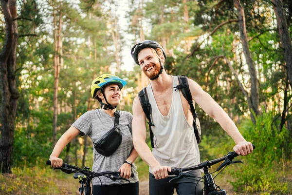 Cycling People. Couple cycle MTB trail track. Outdoor sport activity. Couple With Bikes In Forest. Together on cycle ride in countryside. romantic trip by bicycles. active weekend. sport couple.