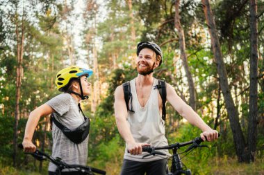 Bisikletli İnsanlar. Birkaç döngü MTB patika yolu. Açık hava spor aktivitesi. Ormanda Bisikletli Çift. Kırsalda bisiklet sürerken. Bisikletle romantik bir gezi. Aktif hafta sonu. spor çifti.