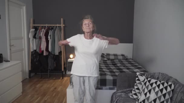 Стара жінка, яка виконує вправи для зменшення стресу під час пандемії Covid-19, запобігає коронавірусу, здорової літньої жінки, вищої фітнесу, залишається вдома. Вік не є виправданням слабкого здоров'я — стокове відео