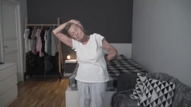 Yaşlı kadın Covid-19 salgını sırasında stresi azaltmak için egzersiz yapıyor, koronavirüsü önlüyor, sağlıklı yaşlı kadın, yaşlı sağlık hizmetleri, evde kalıyor. Yaş, sağlığın bozulması için bir bahane değil.