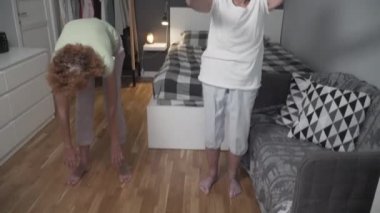 Yatak odasında kızıyla fizik tedavi gören yaşlı bir kadın. Evde, karantinada hoş vakit geçirmek. Aile spordan, sağlıklı bir yaşam tarzından hoşlanır. Evde hemşireyle son sınıf bayan antrenmanı.