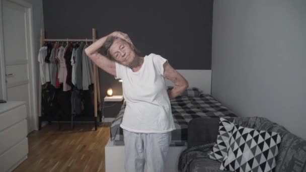 Стара жінка, яка виконує вправи для зменшення стресу під час пандемії Covid-19, запобігає коронавірусу, здорової літньої жінки, вищої фітнесу, залишається вдома. Вік не є виправданням слабкого здоров'я — стокове відео