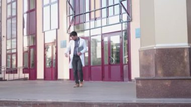Laboratuvar önlüklü genç doktor cep telefonuyla konuşuyor, hastane merdivenlerini terk ediyor. Hastaneden cep telefonuyla çıkan bir tıp çalışanı. Tıp fakültesi öğrencisi binadan çıkarken akıllı telefon kullanıyor.