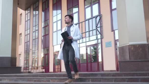 Médecine et santé thème. Étudiant en médecine examine un scanner des poumons à l'extérieur de l'entrée de l'université. Jeune travailleur médical examinant les radiographies d'un patient atteint de coronavirus. Le médecin analyse l'IRM — Video