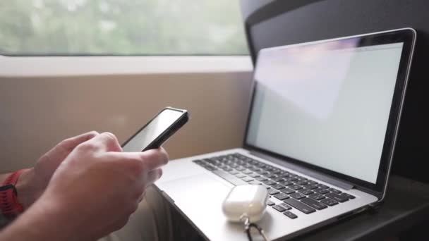 Man working in train, wearing masks to prevent air pollution, dust, PM2.5 pm2, coronavirus or COVID 19. Male passenger surfing internet on smart phone and uses laptop near window. Railway transport — Stock Video