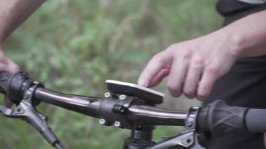 Bisikletçilerin yakın çekimleri GPS navigasyon, inşaat ve planlanan eğitim rotası için aygıt kullanır. İnsan dokunuşu düğmeleri aygıt etkinlik izleyicisi, motor gidonu üzerinde iz sürme ve navigasyon