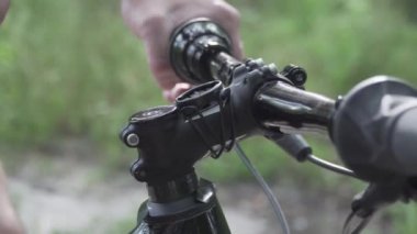 Dağ bisikletindeki GPS cihazı. GPS bilgisayarı devrede. Planlama rotası. Bisiklet dümencisiyle. Spor bisikletli araçlar. Bisiklet yolculuğu. Adam uygulama ekran haritasına dokunup ormanı kapatıyor. İzleyici etkinliği bisikleti