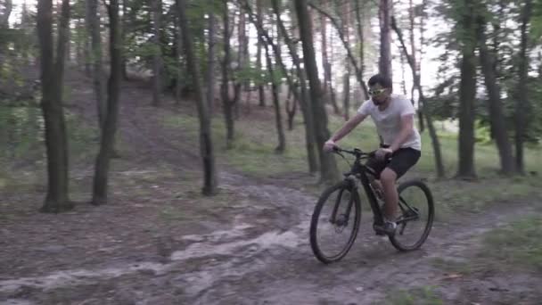 Tema de um ataque cardíaco em um jovem durante esportes ao ar livre. Homem tem sinais de dor no peito de infarto do miocárdio durante o ciclismo no parque. O ciclista pede ajuda, chama uma ambulância, telefone 911 — Vídeo de Stock