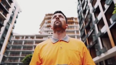 İşçi kulaklarını korumak için kulaklarını kapatır. Koruyucu kulaklık takan inşaat işçisi. İnşaat kavramı, iş sırasında güvenliği sağlamak. Yaralanmaya karşı koruma