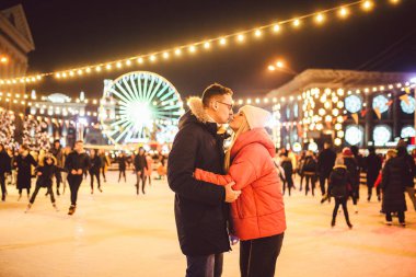 Birlikte buz pateni yapıyoruz. Buz arenasında romantik bir kış tatili. Genç çift buz pateni pistinde kayıyor. En güzel Noel. Kış eğlencesi Sevimli Sevgililer Günü. Yeni yılda çift paten kayıyor. kış tatili.