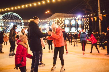 Birlikte buz pateni yapıyoruz. Buz arenasında romantik bir kış tatili. Genç çift buz pateni pistinde kayıyor. En güzel Noel. Kış eğlencesi Sevimli Sevgililer Günü. Yeni yılda çift paten kayıyor. kış tatili.