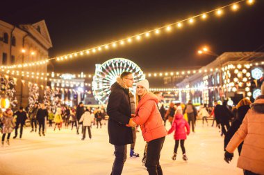 Birlikte buz pateni yapıyoruz. Buz arenasında romantik bir kış tatili. Genç çift buz pateni pistinde kayıyor. En güzel Noel. Kış eğlencesi Sevimli Sevgililer Günü. Yeni yılda çift paten kayıyor. kış tatili.