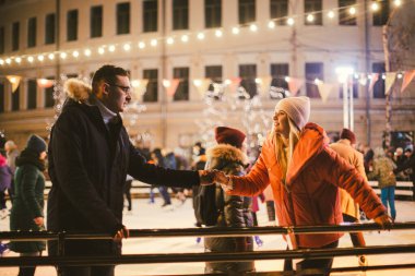 Birlikte buz pateni yapıyoruz. Buz arenasında romantik bir kış tatili. Genç çift buz pateni pistinde kayıyor. En güzel Noel. Kış eğlencesi Sevimli Sevgililer Günü. Yeni yılda çift paten kayıyor. kış tatili.