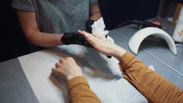 Detailní záběr manikérky, která provádí hydrataci a masáž rukou pro klienta. Tématem je péče o pleť a krásu těla. Lázeňský a manikúra koncept. Měkká kůže. Kosmetologie, aplikace — Stock video