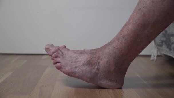 Primo piano di vecchi piedi femminili malati con le dita dei piedi storte e lunghe unghie spaventose. Donna anziana piedi nudi con le dita dei piedi doloranti. Grandi gambe molto vecchie di un anziano pensionato non tagliate unghie terribili gialle — Video Stock