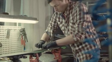 Kayak ustası. Kayak üssü plastik kazıyıcısından fazla mum çıkarıyorum. Kayak servisi ve onarım. Kış işçisi üs onarımı yapıyor. Kiralık atölye servisi. Atölye Kayak Servisi 'nde Tamirci