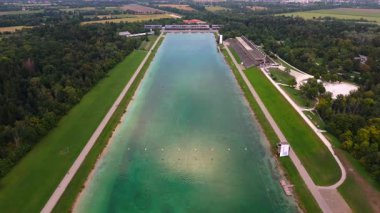 Panorama-Luftaufnahme der Regattastrecke Oberschleissheim, Muenchen, Deutschland. Olimpiyatlar: Erbe, Sport, Freizeit, Baden, Angeln, Tourismus und Drohnenvideo. 