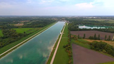 Münih Olimpiyat Yarış Merkezi 'nin hava manzarası, Almanya. Dachauer Moos 'da tarihi kürek ve kano sprint sahası, manzaralı Bavyera gölü, düz su sahası, tribün ve olimpiyat mirası.
