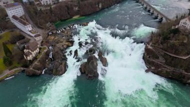 İsviçre 'de Neuhausen am Rheinfall ile Laufen-Uhwiesen arasında geçen Rheinfall' un insansız hava aracı görüntüleri. Bu hava videosu kükreyen suları, sisli çağlayanları ve çarpıcı doğal manzarayı yakalar.. 