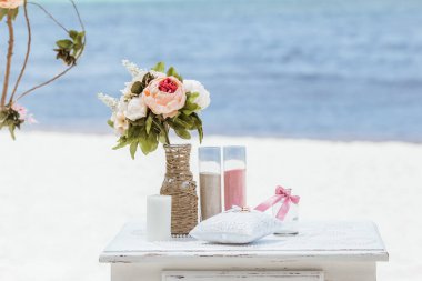 Gelin ve damat kristal vazoya renkli kumlar döküyor. Sembolik deniz dekoru merasimi sırasında okyanusun önündeki kumlu kumsalda evlilik birleşme töreni sırasında kapatılıyor. 