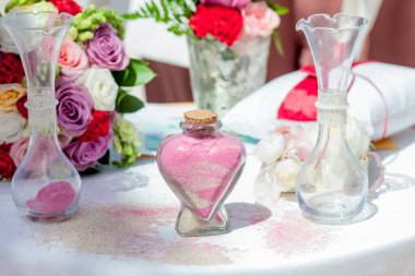 Gelin ve damat kristal vazoya renkli kumlar döküyor. Sembolik deniz dekoru merasimi sırasında okyanusun önündeki kumlu kumsalda evlilik birleşme töreni sırasında kapatılıyor. 