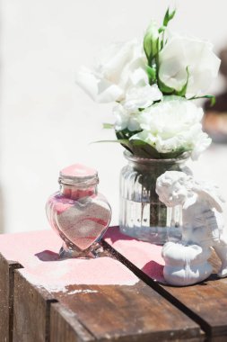 Gelin ve damat kristal vazoya renkli kumlar döküyor. Sembolik deniz dekoru merasimi sırasında okyanusun önündeki kumlu kumsalda evlilik birleşme töreni sırasında kapatılıyor. 