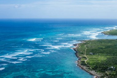 Punta Cana manzarası, Bavaro, Saona, Cap Cana tropikal okyanus denizi ve Dominik Cumhuriyeti 'ndeki turist ve teknelerle Karayip kıyılarındaki palmiye ağaçları üzerindeki plaj insansız hava aracı görüntüsü.  