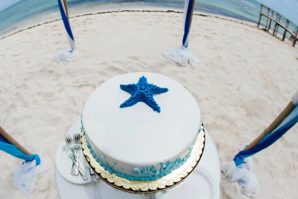 Wedding cake decorated for bride and groom to cut during tropical destination caribbean wedding marriage outdoor ceremony on the sandy beach in Dominican republic