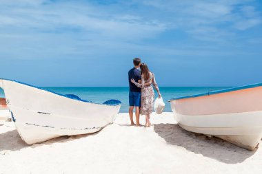 Aşk yaşayan romantik bir çift, balayı tatillerinde kumsalda sarılıp, öpüşüp, koşuyor. Dominik Cumhuriyeti 'ndeki Karayip manzarası Punta Cana 