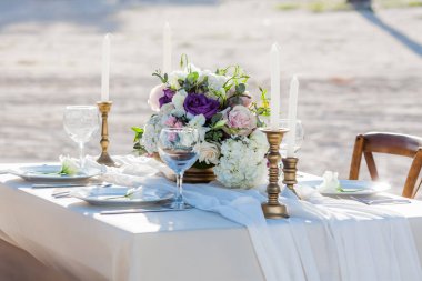 Tabaklar, bardaklar, mumlar, peçeteler, lambalar, çiçekler ve davetiyelerle parti etkinliği için servis edildi ve dekore edildi. Misafir masası, düğün resepsiyonu, doğum günü, yıldönümü. Tatil akşamı.