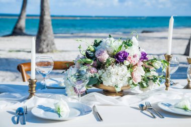 Tabaklar, bardaklar, mumlar, peçeteler, lambalar, çiçekler ve davetiyelerle parti etkinliği için servis edildi ve dekore edildi. Misafir masası, düğün resepsiyonu, doğum günü, yıldönümü. Tatil akşamı.