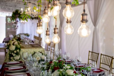 Tabaklar, bardaklar, mumlar, peçeteler, lambalar, çiçekler ve davetiyelerle parti etkinliği için servis edildi ve dekore edildi. Misafir masası, düğün resepsiyonu, doğum günü, yıldönümü. Tatil akşamı.