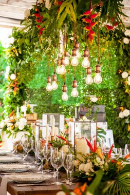 Tabaklar, bardaklar, mumlar, peçeteler, lambalar, çiçekler ve davetiyelerle parti etkinliği için servis edildi ve dekore edildi. Misafir masası, düğün resepsiyonu, doğum günü, yıldönümü. Tatil akşamı.