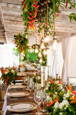 Tabaklar, bardaklar, mumlar, peçeteler, lambalar, çiçekler ve davetiyelerle parti etkinliği için servis edildi ve dekore edildi. Misafir masası, düğün resepsiyonu, doğum günü, yıldönümü. Tatil akşamı.