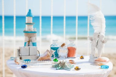 Düğün aksesuarları, dekorasyon, çiçekler ve plajda tropikal evlilik töreni için dekoratif masa. 