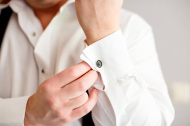 Sabah damat hazırlanırken kol düğmeleri etek giyiyor. Düğün töreni için kol düğmesi
