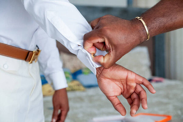 Cufflinks putting on the skirt during groom getting ready morning. Cufflink for wedding marriage ceremony