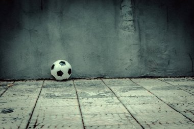 Klasik siyah ve beyaz futbol topu gri duvarının yakınında