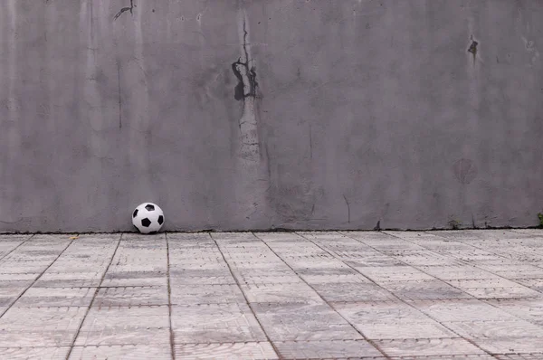 classic black and white soccer ball near the gray wall