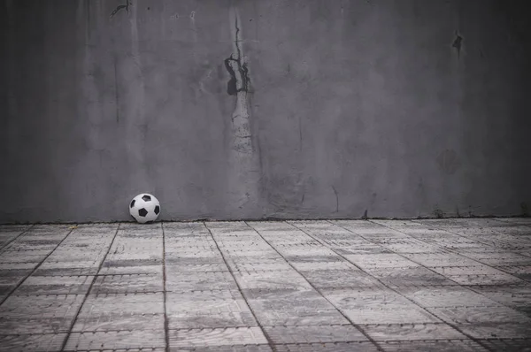 classic black and white soccer ball near the gray wall