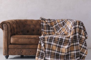 kahverengi deri kanepe gri duvara karşı